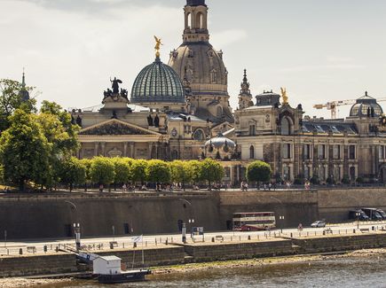 Die Brühlschen Terrassen in Dresden sind zu sehen. Im Vordergrund fließt der Fluss Elbe. Im Hintergrund ist die Frauenkirche.