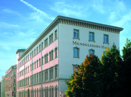 Das Mendelssohnhaus in Leipzig ist von außen abgebildet. Neben dem Haus stehen Bäume und vor dem Haus ist eine Straße mit Autos.